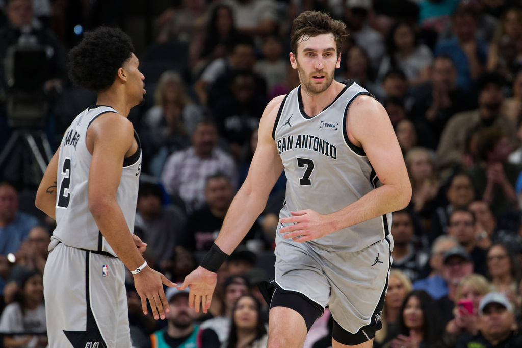 San Antonio Spurs center Luke Kornet (7) celebrates a basket with teammate Dylan Harper during the first half of their NBA basketball game against the Portland Trail Blazers, Wednesday, April 8, 2026, in San Antonio. (AP Photo/Darren Abate)