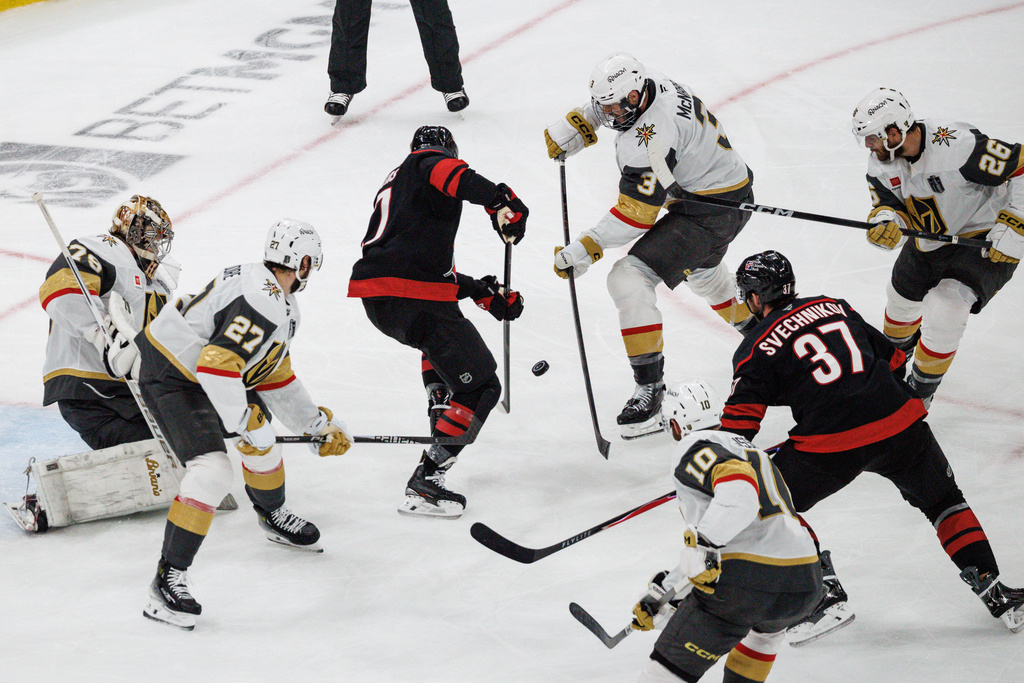 Vegas Golden Knights' Brayden McNabb (3) and Carolina Hurricanes' Nikolaj Ehlers (27) battle for the puck against the Carolina Hurricanes during the second period of Game 5 of the NHL hockey Stanley Cup Final series in Raleigh, N.C., Thursday, June 11, 2026. (AP Photo/Ben McKeown)