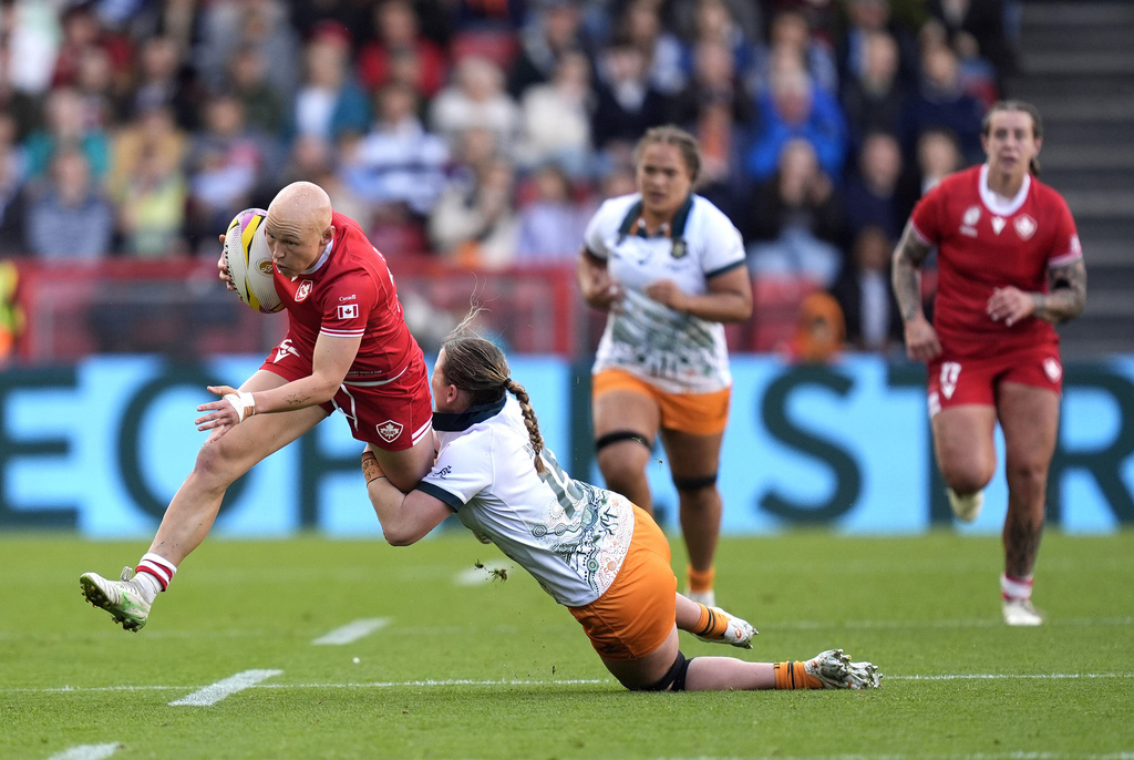 Canada's Olivia Apps is tackled by Australia's Caitlyn Halse during the Women's Rugby World Cup quarterfinal match, Saturday, Sept. 13, 2025, at Ashton Gate, Bristol, England. (Andrew Matthews/PA via AP)
