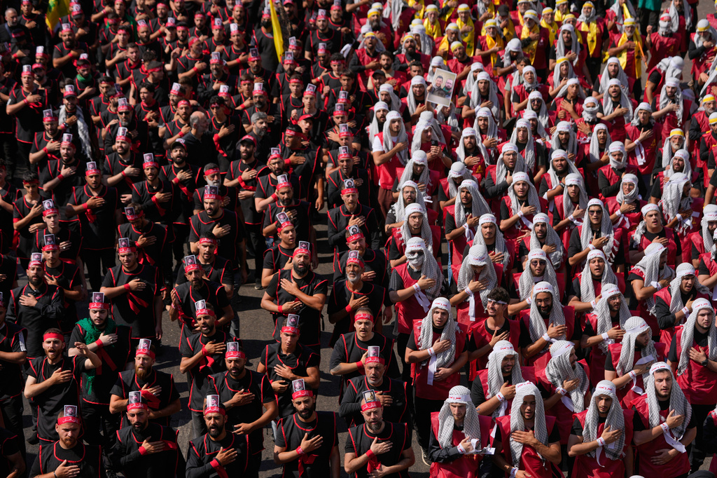 Hezbollah supporters beat their chests, as they march during the holy day of Ashoura that commemorates the 7th century martyrdom of the Prophet Muhammad's grandson Hussein, in Dahiyeh, Beirut's southern suburbs, Lebanon, Friday, June 26, 2026. (AP Photo/Hussein Malla)