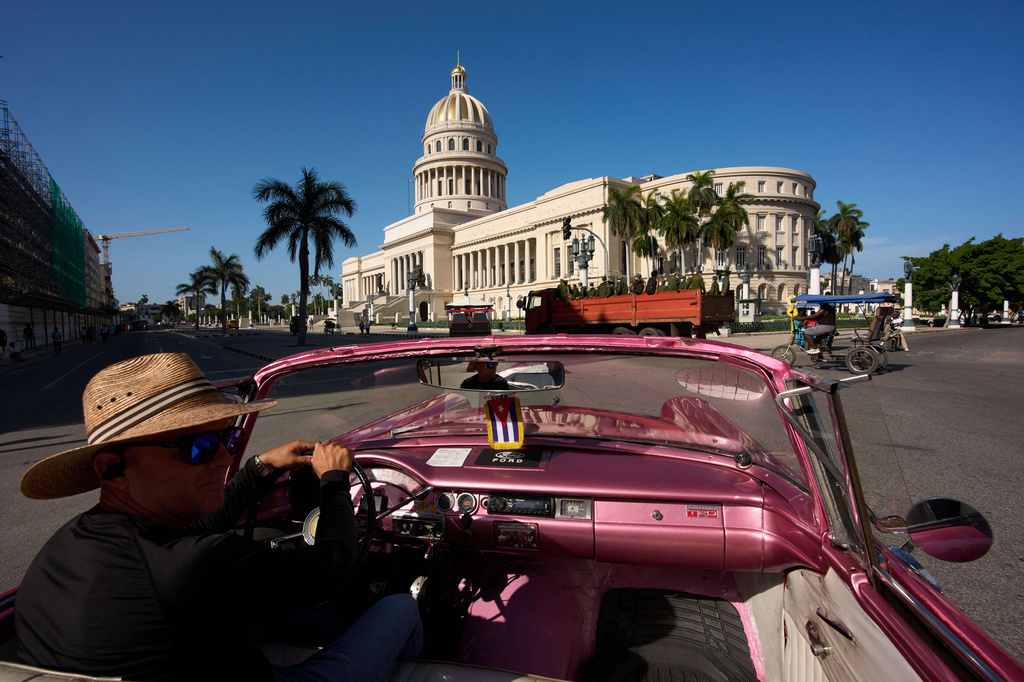A taxi driver navigates his classic American car past the "Capitolio," inspired by the U.S. Capitol among other iconic buildings around the world, in Havana, Cuba, Thursday, June 25, 2026. (AP Photo/Ramon Espinosa)