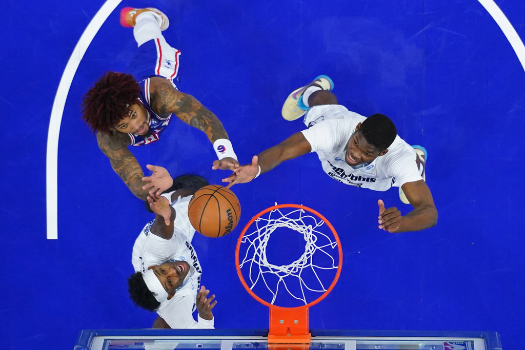Philadelphia 76ers' Kelly Oubre Jr., top left, Memphis Grizzlies' Cedric Coward, right, and Olivier-Maxence Prosper battle for the ball during the first half of an NBA basketball game, Tuesday, March 10, 2026, in Philadelphia. (AP Photo/Matt Rourke)