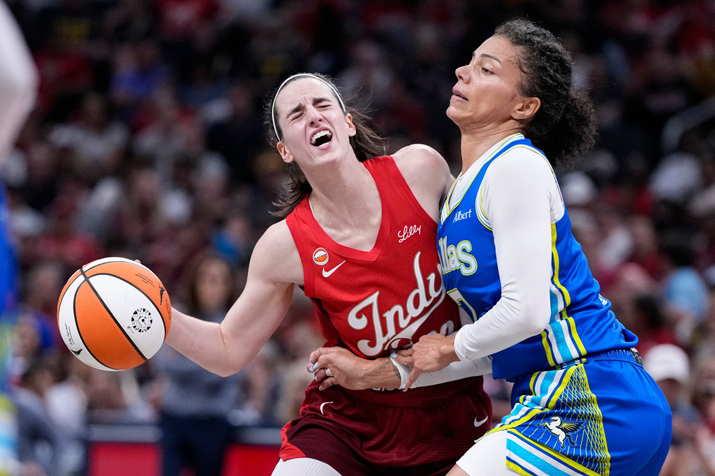 Indiana Fever guard Caitlin Clark, left, is fouled by Dallas Wings forward Alysha Clark, right, in the first half of a WNBA basketball game in Indianapolis, Friday, Aug. 14, 2026. (AP Photo/Michael Conroy)