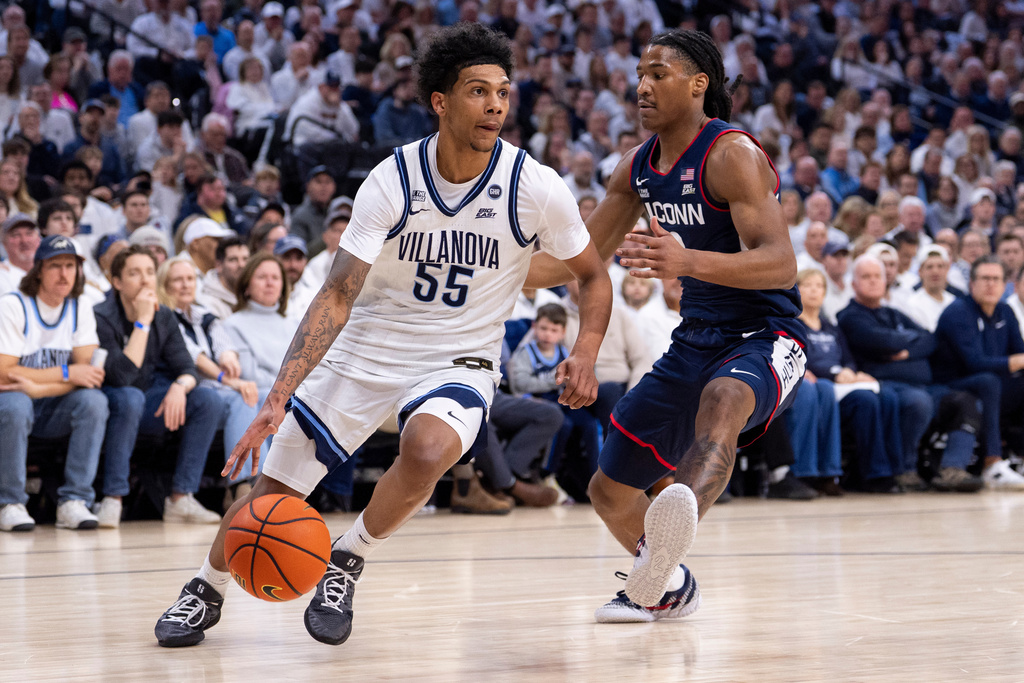 Villanova's Acaden Lewis, left, drives to the basket against UConn's Silas Demary Jr., right, during the first half of an NCAA college basketball game, Saturday, Feb. 21, 2026, in Philadelphia. (AP Photo/Chris Szagola)