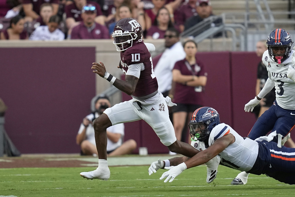 Texas A&M's Marcel Reed (10) scrambles away from UTSA's Vic Shaw during the first half of an NCAA college football game Saturday, Aug. 30, 2025, in College Station, Texas. (AP Photo/David J. Phillip)