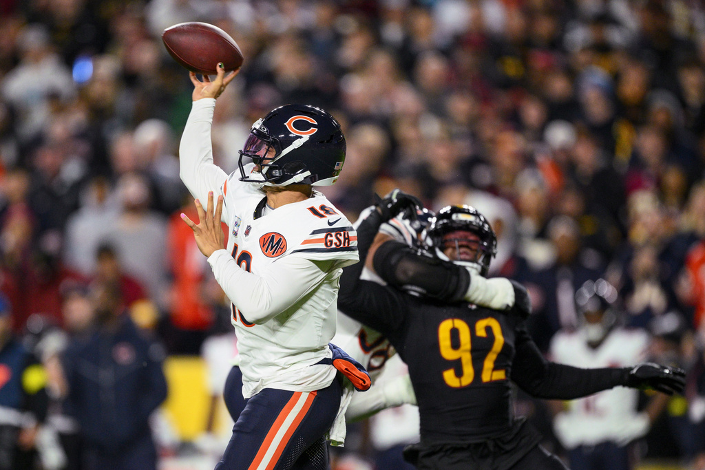 Chicago Bears quarterback Caleb Williams (18) throws under pressure from Washington Commanders defensive end Dorance Armstrong (92) during the first half of an NFL football game Monday, Oct. 13, 2025, in Landover, Md. (AP Photo/Nick Wass)