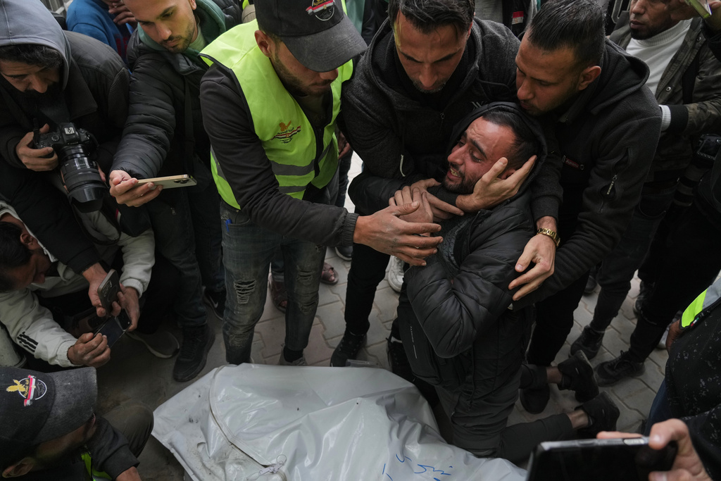 People mourn over the bodies of the Palestinian journalists Abd Shaat and Mohamed Qeshta, who were killed in an Israeli strike on a vehicle, before their funeral at Shifa Hospital, in Gaza City, Wednesday, Jan. 21, 2026. (AP Photo/Jehad Alshrafi)