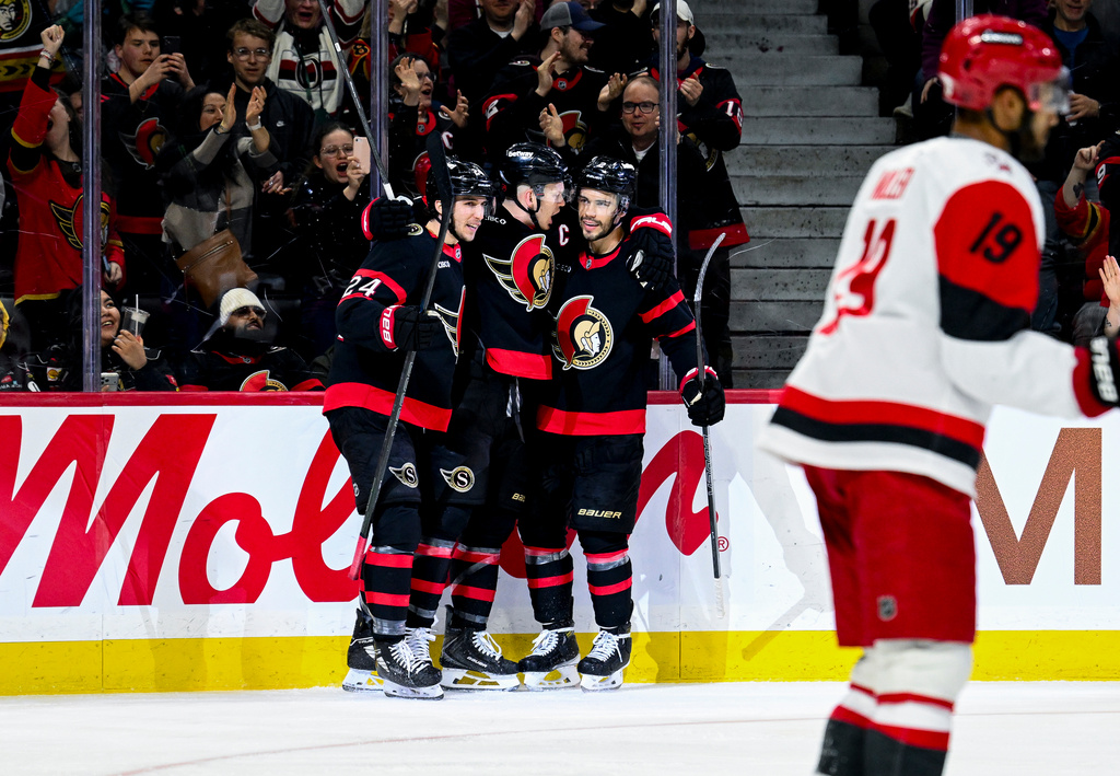 Ottawa Senators' Brady Tkachuk (7), centre, celebrates his goal on Carolina Hurricanes goaltender Frederik Andersen (31), not pictured, with teammate Ottawa Senators' Dylan Cozens (24), left, and Artem Zub (2) during the second period of an NHL hockey game, in Ottawa, Ontario, Sunday, April 5, 2026. (Spencer Colby/The Canadian Press via AP)