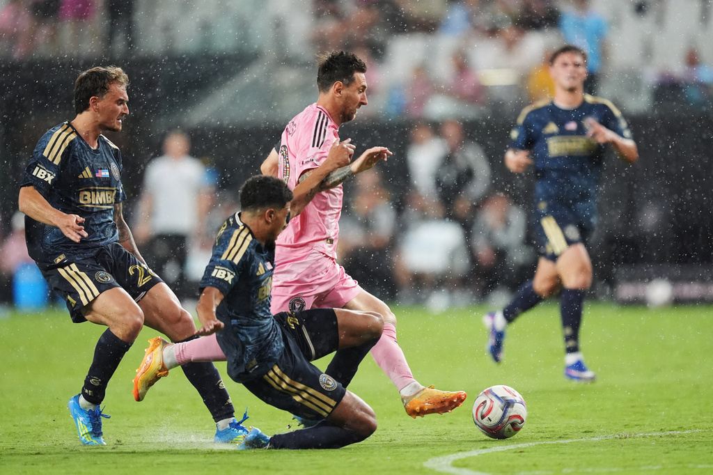 Inter Miami forward Lionel Messi, center, drives forward under pressure from Philadelphia Union forward Augustin Anello, left, and defender Nathan Harriel, bottom, during the second half of an MLS soccer match, Sunday, May 24, 2026, in Miami. (AP Photo/Rebecca Blackwell)