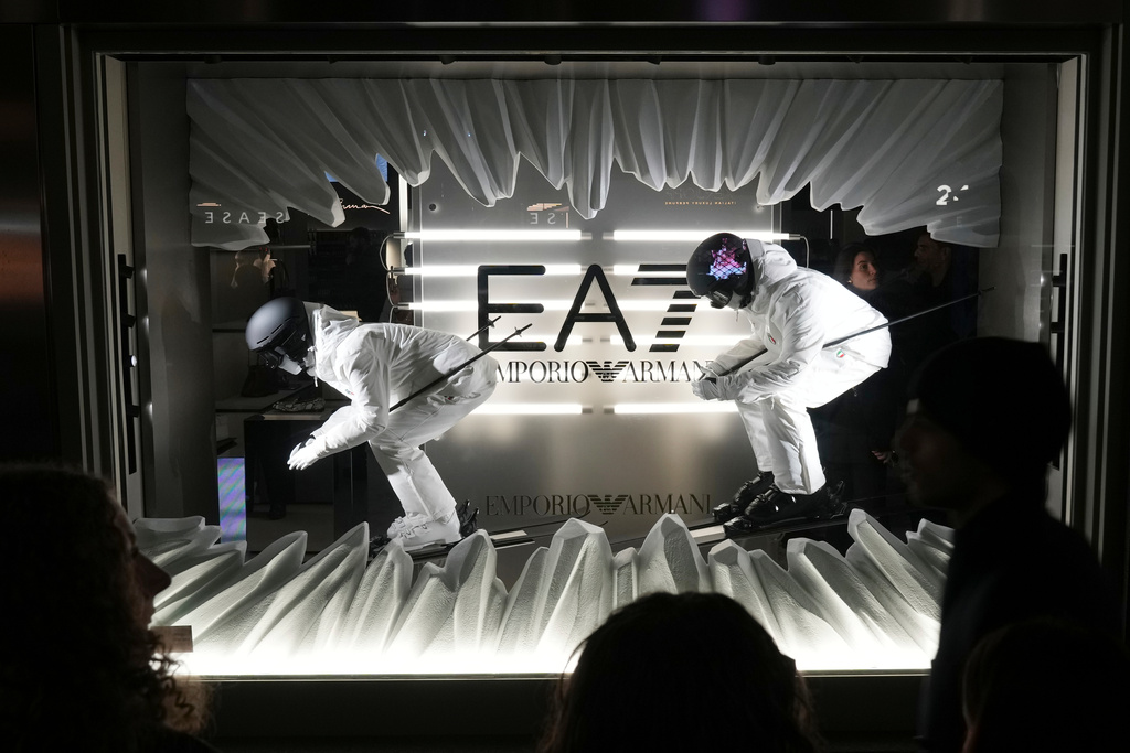 People watch the shop window during an event to celebrate Milan Cortina 2026 Winter Olympics at the Emporio Armani store, during the Fall/Winter 2026-2027 Men's fashion week, in Milan, Italy, Saturday, Jan. 17, 2026. (AP Photo/Antonio Calanni)
