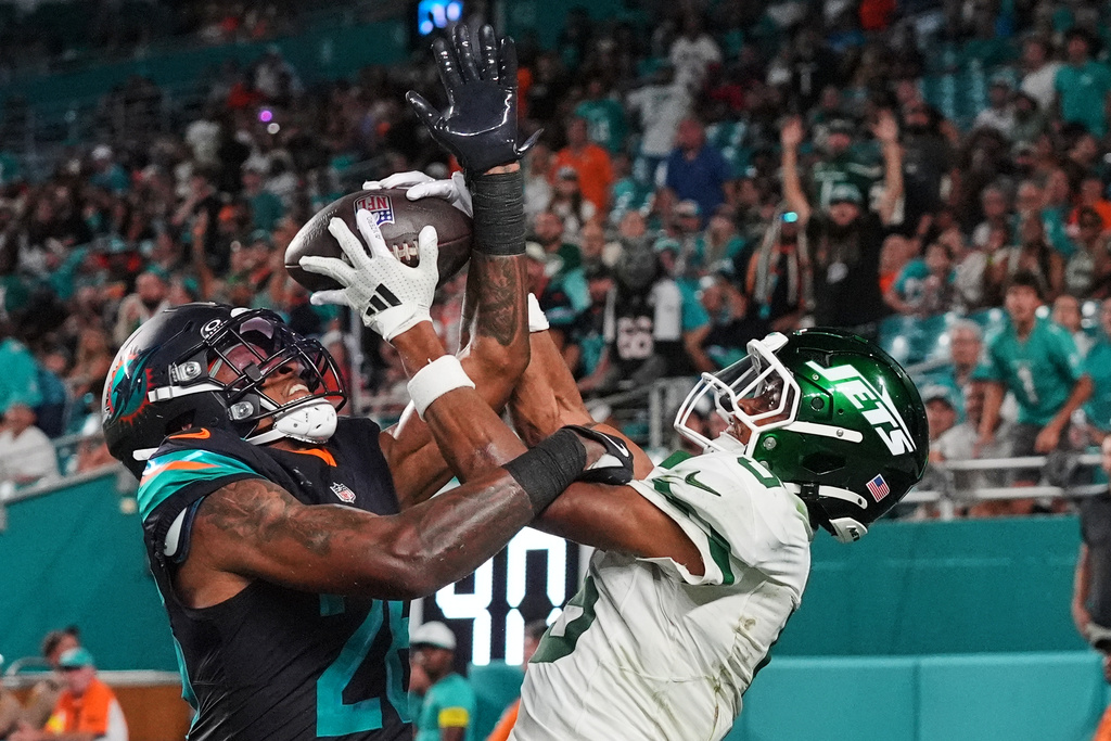 New York Jets wide receiver Garrett Wilson, right, catches a touchdown pass as Miami Dolphins cornerback Rasul Douglas (26) defends in the second half of an NFL football game, Monday, Sept. 29, 2025, in Miami Gardens, Fla. (AP Photo/Marta Lavandier)