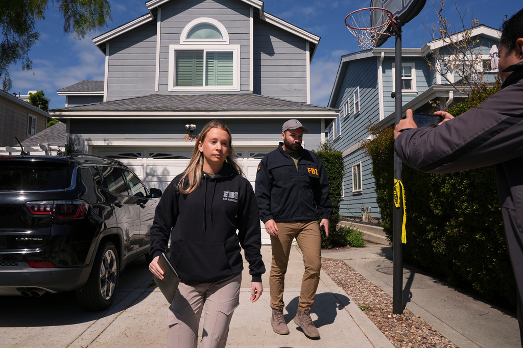 FBI agents walk door to door to try to speak with neighbors as members of the media follow them, Sunday, April 26, 2026, near an address in Torrance, Calif., connected to Cole Tomas Allen, who was identified as the shooting suspect at the White House Correspondents Dinner the night before. (AP Photo/Damian Dovarganes)