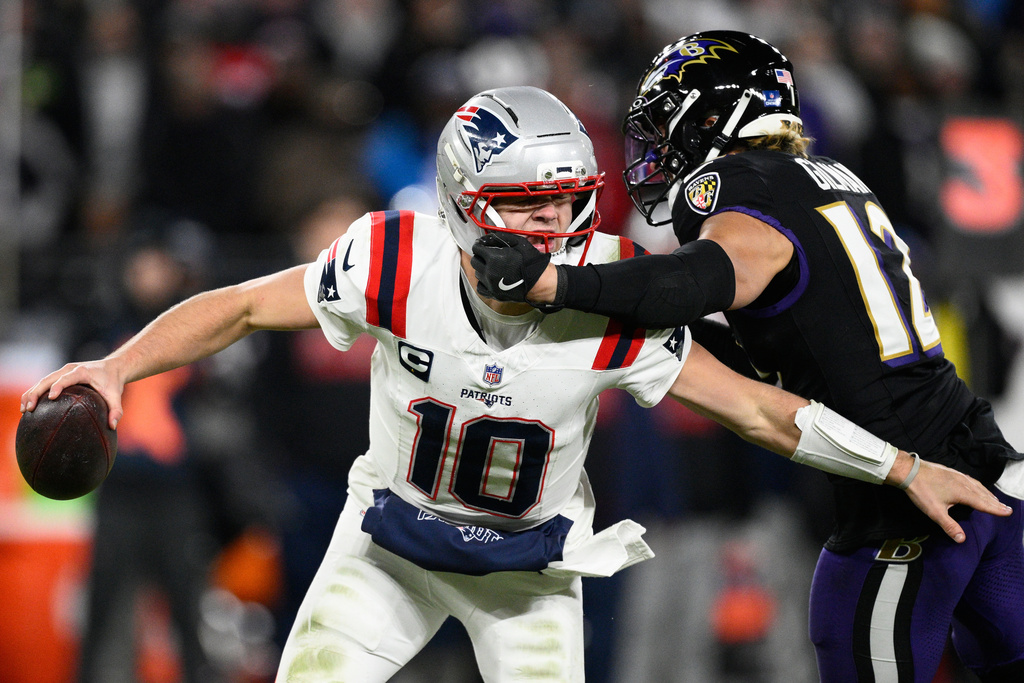New England Patriots quarterback Drake Maye (10) is pressured by Baltimore Ravens safety Alohi Gilman (12) during the second half of an NFL football game, Sunday, Dec. 21, 2025, in Baltimore. (AP Photo/Nick Wass)