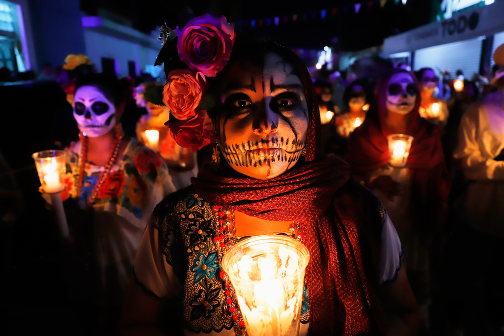 People with skull make up march during the Paseo de las Animas parade as part of the Day of the Dead celebrations in Merida, Mexico, Friday, Oct. 31, 2025. (AP Photo/Martin Zetina)