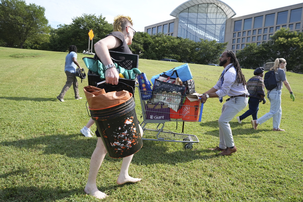 Volunteers help the homeless move their things, at a tent encampment, Thursday, Aug. 14, 2025 in Washington. (AP Photo/Jacquelyn Martin)