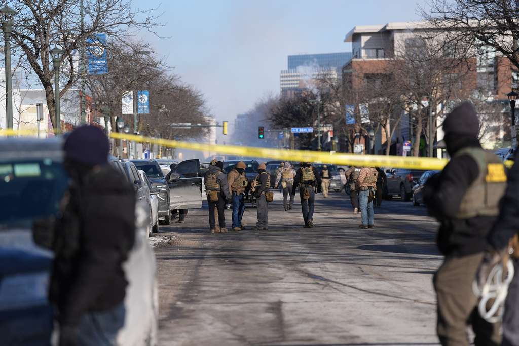 Federal agents stand near the site of a shooting Saturday, Jan. 24, 2026, in Minneapolis. (AP Photo/Abbie Parr)