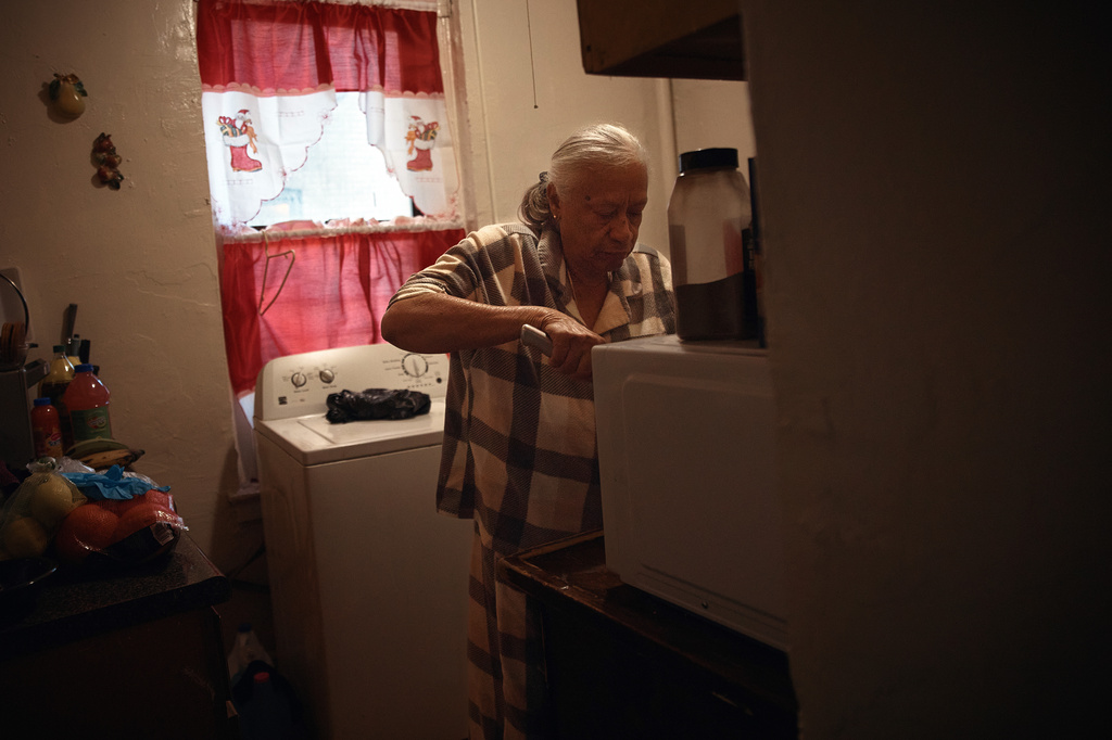 Maria Rodriguez prepares food in an apartment building where tenants report maintenance issues and pest infestations, in the Bronx borough of New York, Tuesday, March 17, 2026. (AP Photo/Andres Kudacki)