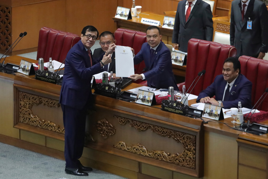 FILE - Indonesian Law and Human Right Minister Yasonna Laoly, left, pose for the media with Deputy House Speaker Sufmi Dasco Ahmad, center, during a session ratifying the country's new criminal code at the parliament building in Jakarta, Indonesia, Tuesday, Dec. 6, 2022. (AP Photo, File)