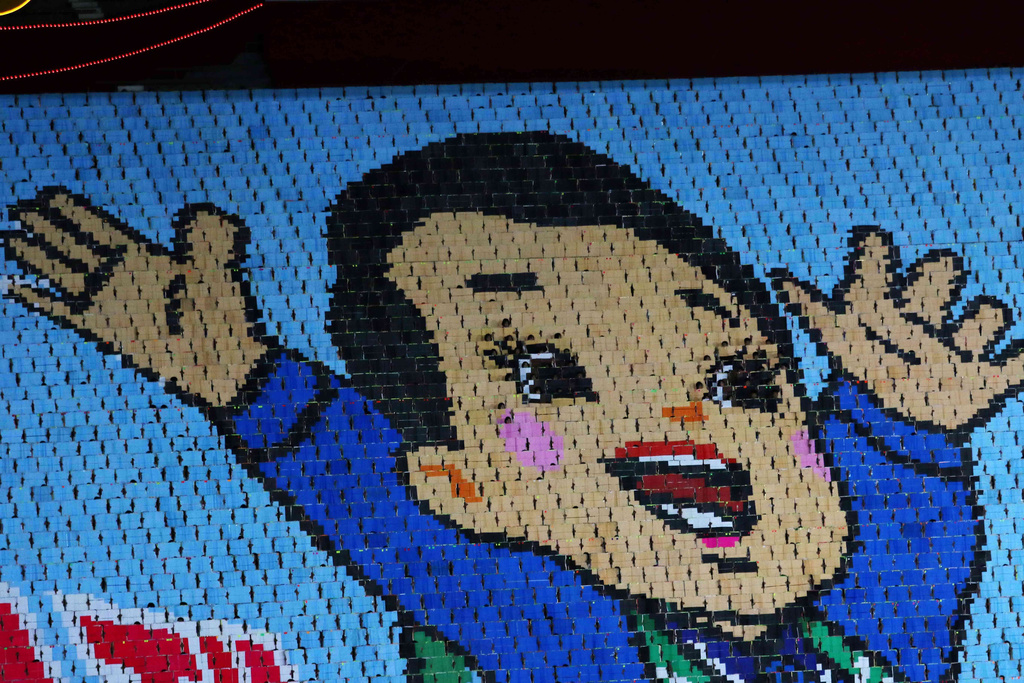 People turn cards to form an image of a child during the ceremony marking the 80th anniversary of the founding of the ruling Workers' Party at the May Day Stadium in Pyongyang, North Korea, Thursday, Oct. 9, 2025. (AP Photo/Cha Song Ho)