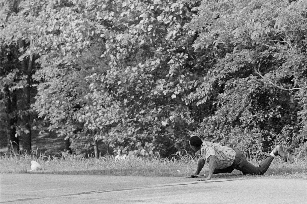 FILE - James Meredith looks at Aubrey James Norvell, background left partially hidden behind foliage, after being shot on a road near Hernando, Miss., June 6, 1966. (AP Photo/Jack Thornell, File)