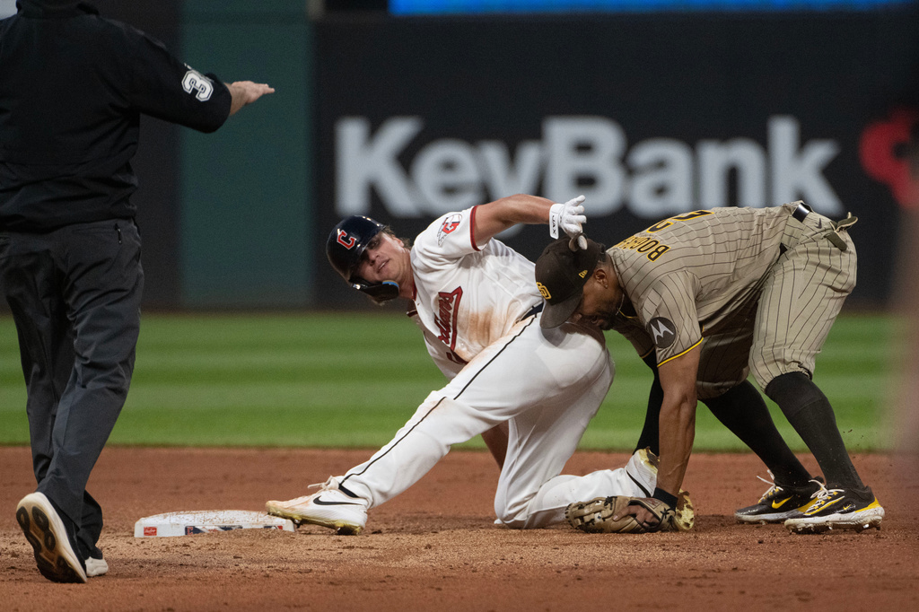 Cleveland Guardians' Petey Halpin, center, is safe at second base with a steal as San Diego Padres' Xander Bogaerts is late with the tag and umpire Tyler Jones calls the play during the fifth inning of a baseball game, Saturday, Aug. 15, 2026, in Cleveland. (AP Photo/Phil Long)
