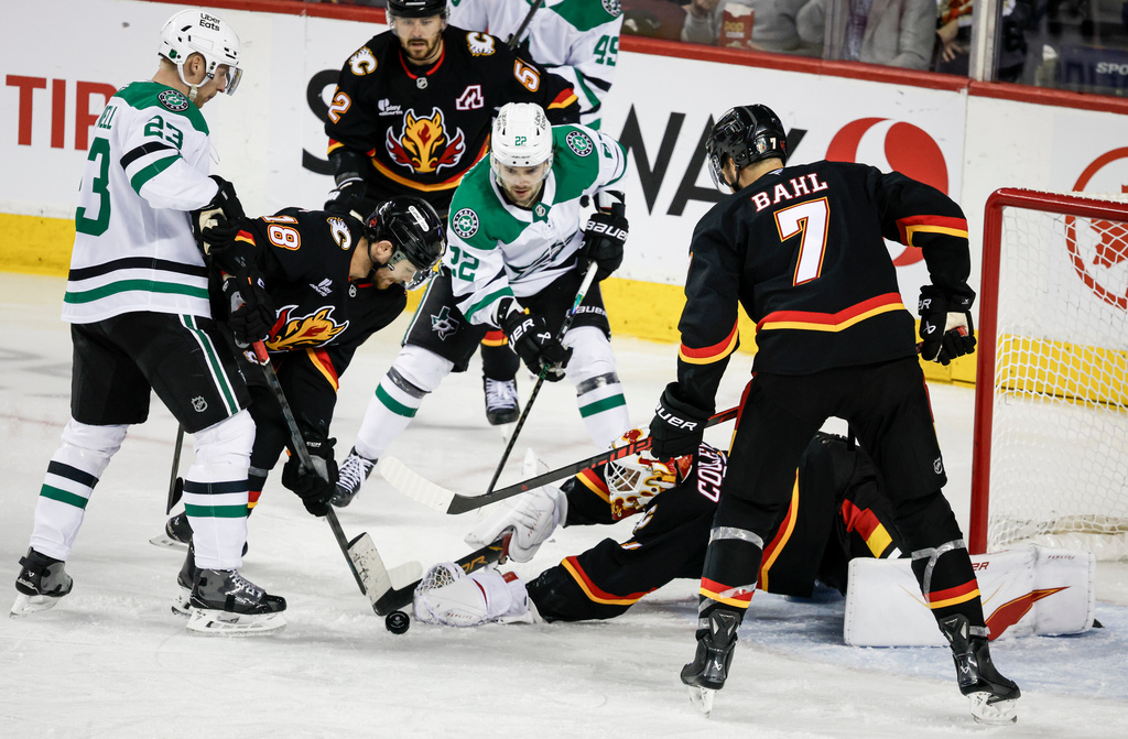 Dallas Stars' Mavrik Bourque (22) looks on as Calgary Flames goalie Devin Cooley dives for the puck during the third period of an NHL hockey game in Calgary, Alberta on Tuesday, March 3, 2026. (Jeff McIntosh/The Canadian Press via AP)