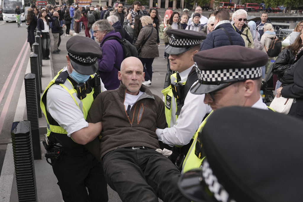Police remove a protester after a banner was unfurled on Westminster Bridge, London, as part of a demonstration organised by Defend our Juries, in support of Palestine Action, Saturday Oct. 4, 2025. (Stefan Rousseau/PA via AP)