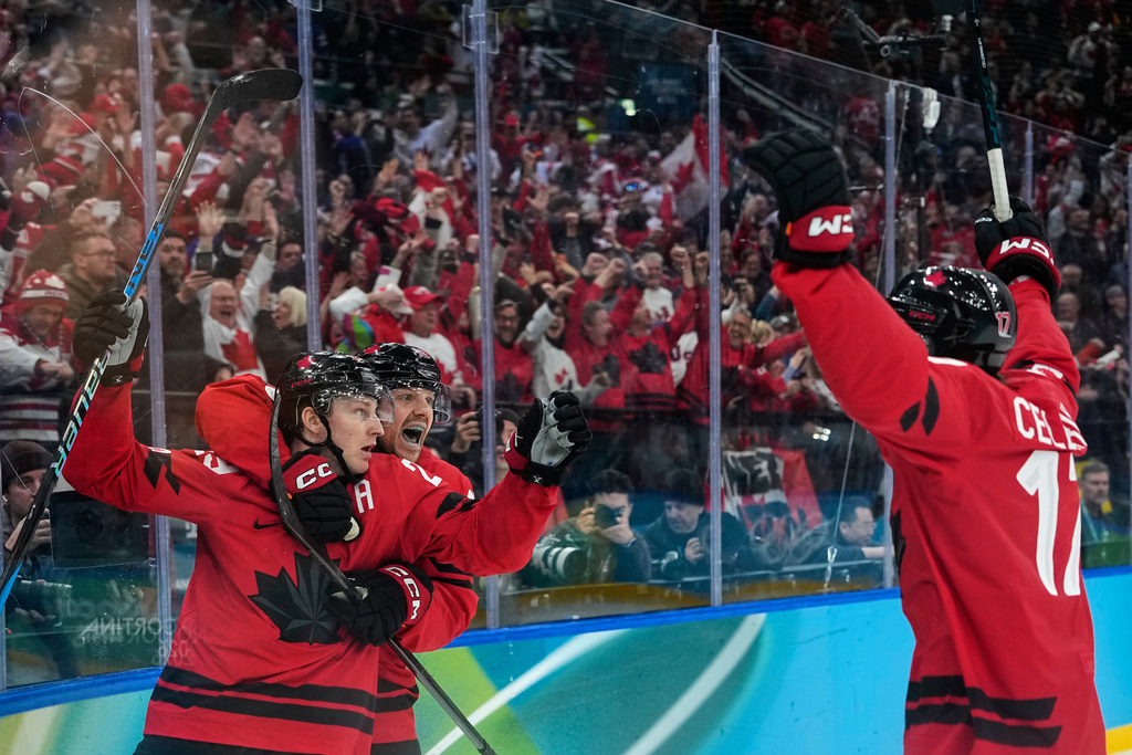 Canada's Nathan MacKinnon (29) celebrates with teammates after scoring his side's third goal during a men's ice hockey semifinal game between Canada and Finland at the 2026 Winter Olympics, in Milan, Italy, Friday, Feb. 20, 2026. (AP Photo/Petr David Josek)