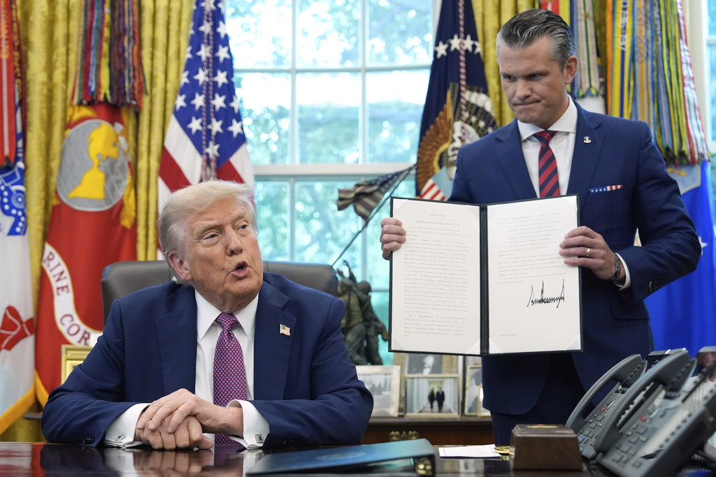 President Donald Trump speaks as Defense Secretary Pete Hegseth holds a signed executive order in the Oval Office of the White House, Friday, Sept. 5, 2025, in Washington. (AP Photo/Alex Brandon)