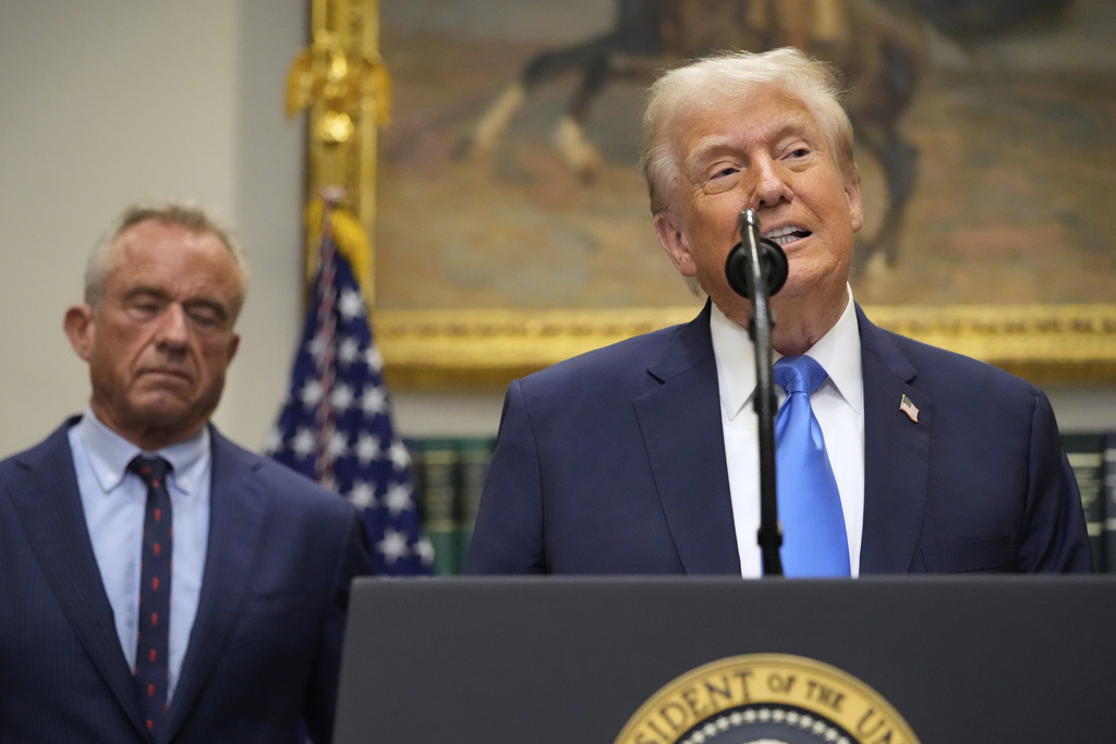 President Donald Trump speaks in the Roosevelt Room of the White House, Monday, Sept. 22, 2025, in Washington, as Health and Human Services Secretary Robert F. Kennedy Jr. listens. (AP Photo/Mark Schiefelbein)