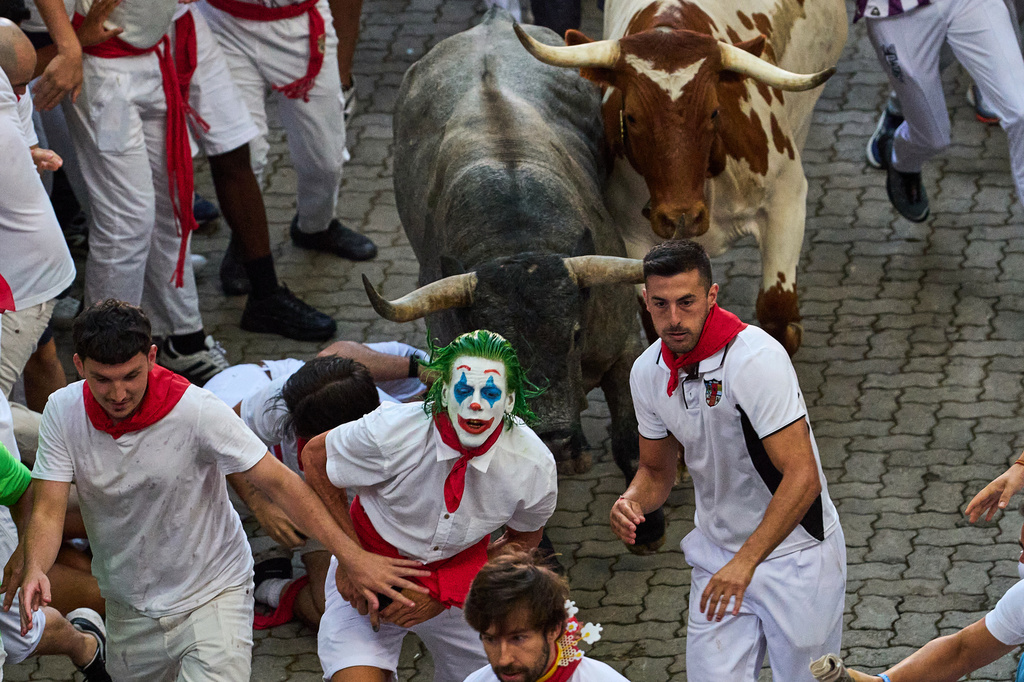 Revelers run alongside Jose Escolar's fighting bulls during the fifth running of the bulls at the San Fermín festival in Pamplona, Spain, Saturday, July 11, 2026. (AP Photo/Miguel Oses)