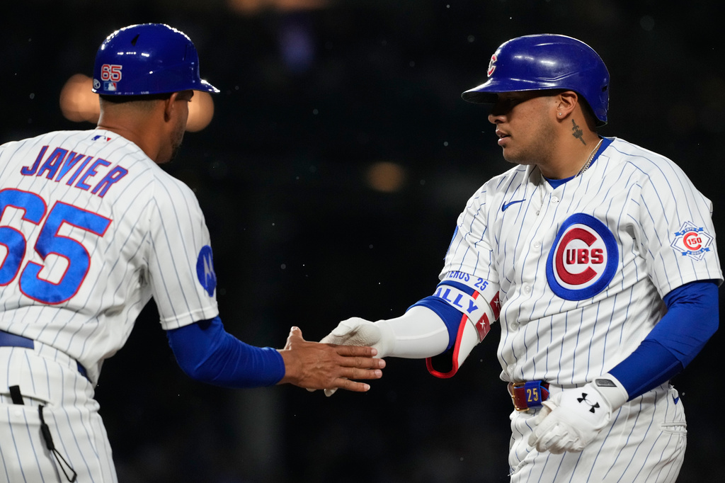 Chicago Cubs' Moisés Ballesteros, right, celebrates with first base coach Jose Javier after hitting a one-run single during the third inning of a baseball game against the San Francisco Giants in Chicago, Sunday, June 7, 2026. (AP Photo/Nam Y. Huh)
