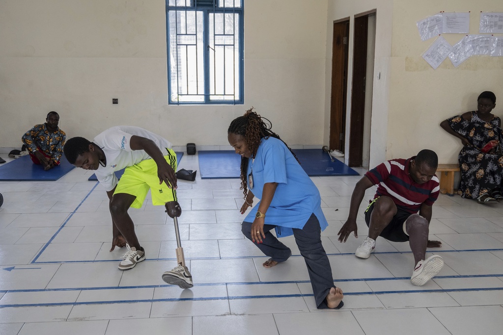 Physiotherapist Gisèle Kantu, center, works with amputees wounded by fighting in the region, at an orthopedic center run by the Catholic church and supported by Red Cross in Goma, eastern Congo, Friday, Aug. 29, 2025. (AP Photo/Moses Sawasawa)