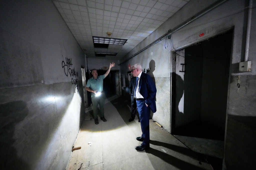 Patrick Norton, Tulane University senior vice president, chief operating officer and treasurer, right, and Jeff Benjamin, vice president of facilities and campus development, talk in a hallway inside the old Charity Hospital building Wednesday, Aug. 19, 2026, in New Orleans. (AP Photo/Gerald Herbert)