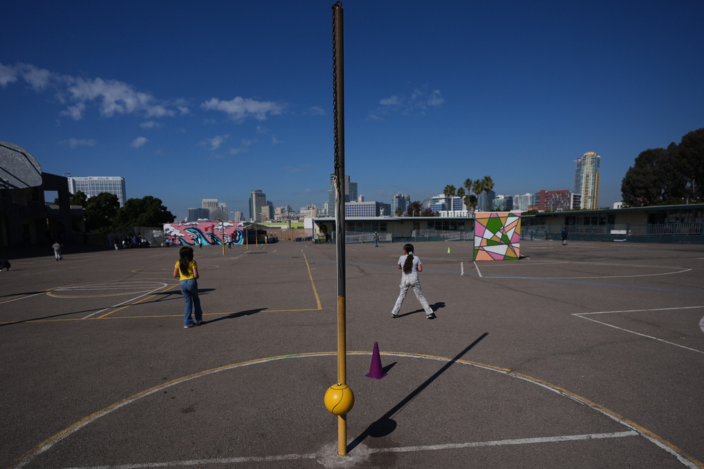 Children play on a sparse playground at Perkins K-8 School Thursday, Nov. 13, 2025, in San Diego. (AP Photo/Gregory Bull)