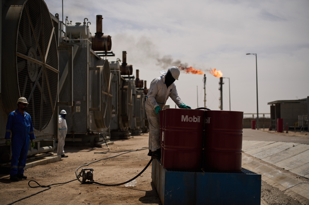 A worker collects engine oil as he works at a degassing station in Zubair oil field, whose operations have being reduced due to the Mideast war triggered by the U.S. and Israeli attacks on Iran, near Basra, Iraq, Saturday, March 28, 2026. (AP Photo/Leo Correa)