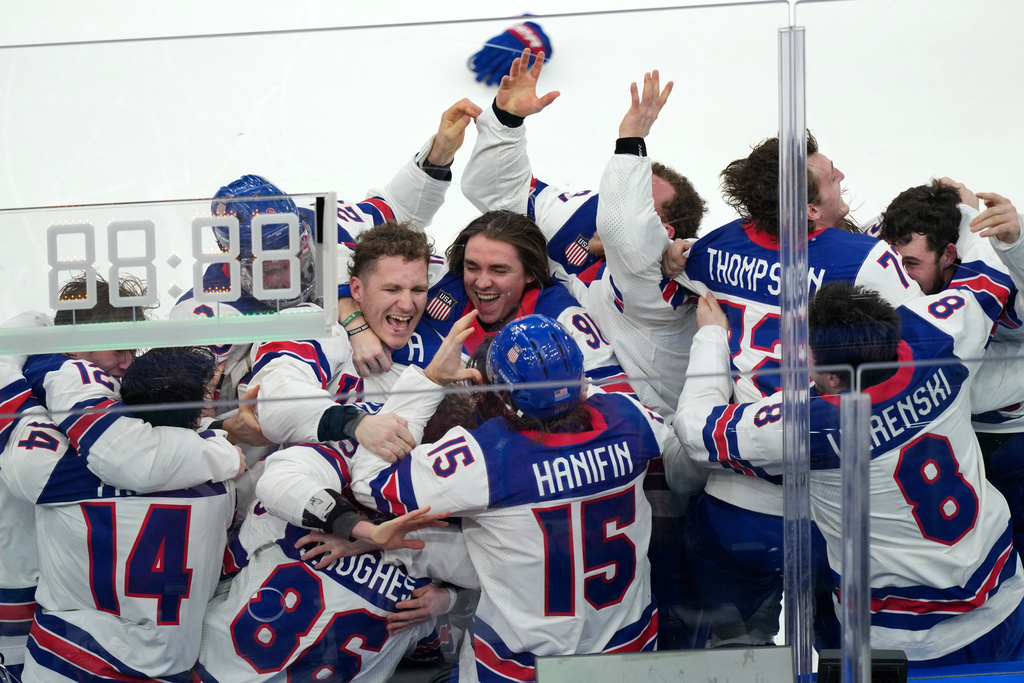 United States players celebrate after defeating Canada 2-1 in overtime to win the men's ice hockey gold medal game at the 2026 Winter Olympics in Milan, Italy, Sunday, Feb. 22, 2026. (AP Photo/Carolyn Kaster)