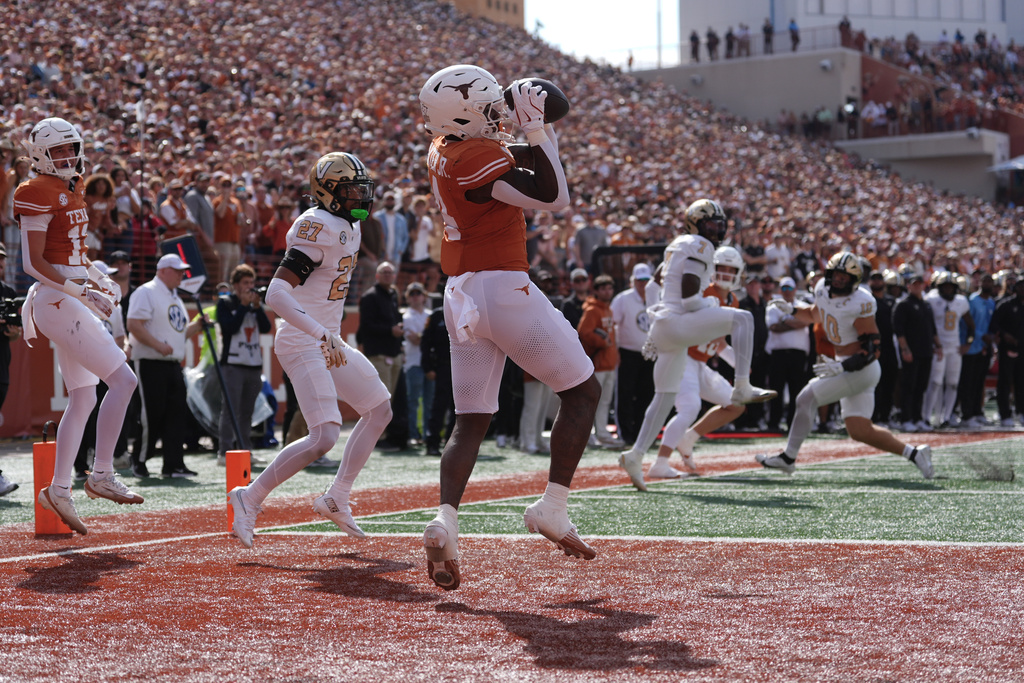 Texas running back CJ Baxter (4) makes a catch for a touchdown in front of Vanderbilt cornerback Jaylin Lackey (27) during the first half of an NCAA college football game in Austin, Texas, Saturday, Nov. 1, 2025. (AP Photo/Eric Gay)