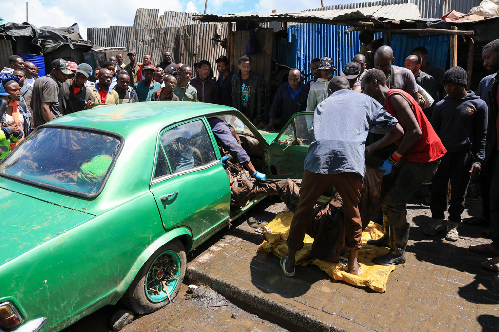 Volunteers retrieve the body of a man from a car after heavy rains in Nairobi, Kenya, Saturday, March 7, 2026. (AP Photo/Andrew Kasuku)