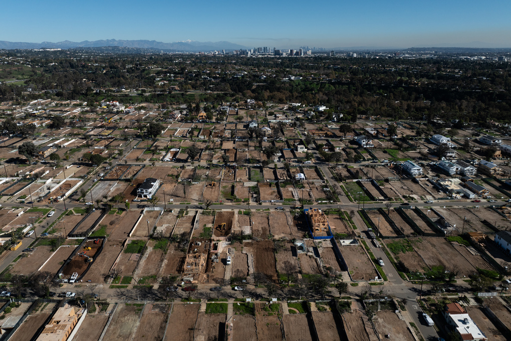 An aerial view shows cleared lots and rebuilding in the Pacific Palisades neighborhood of Los Angeles, Friday, Dec. 5, 2025, months after the Palisades Fire. (AP Photo/Jae C. Hong)