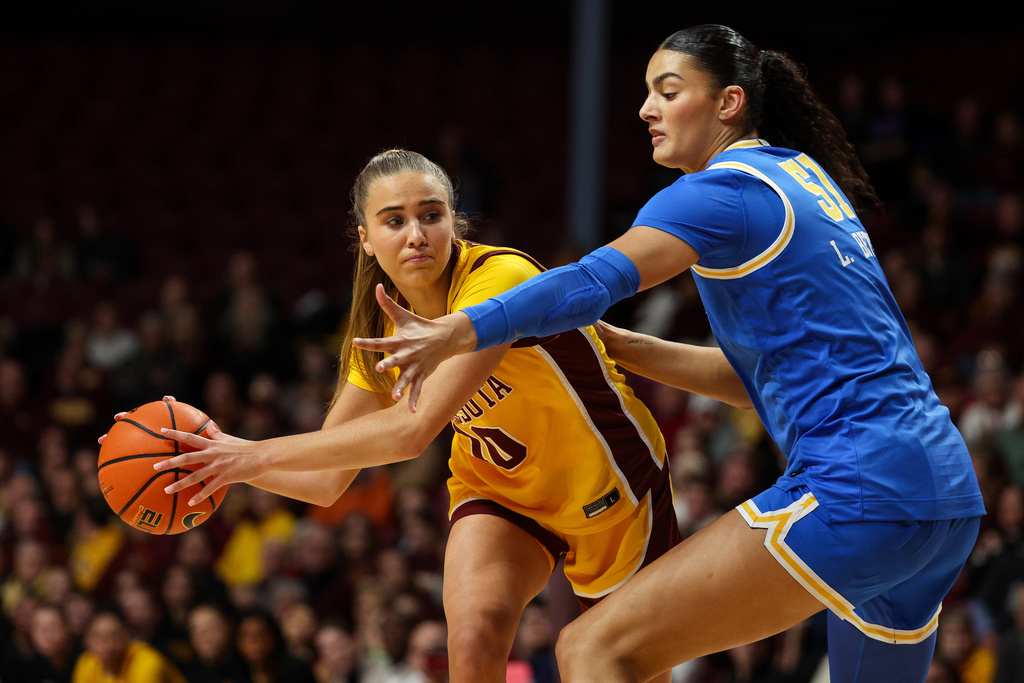 Minnesota Golden Gophers guard Mara Braun, left, looks to pass against UCLA Bruins center Lauren Betts (51) during the second half of an NCAA college basketball game, Wednesday, Jan. 14, 2026, in Minneapolis. (AP Photo/Matt Krohn)