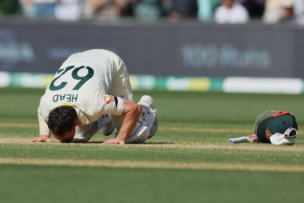 Australia's Travis Head kisses the pitch after scoring a century during play on day three of the third Ashes cricket test between England and Australia in Adelaide, Australia, Friday, Dec. 19, 2025. (AP Photo/James Elsby)