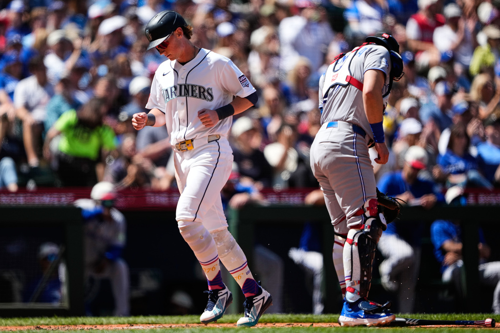 Seattle Mariners' Colt Emerson scores on an RBI single from Dominic Canzone as Toronto Blue Jays catcher Brandon Valenzuela looks away during the sixth inning of a baseball game, Saturday, July 4, 2026, in Seattle. (AP Photo/Lindsey Wasson)