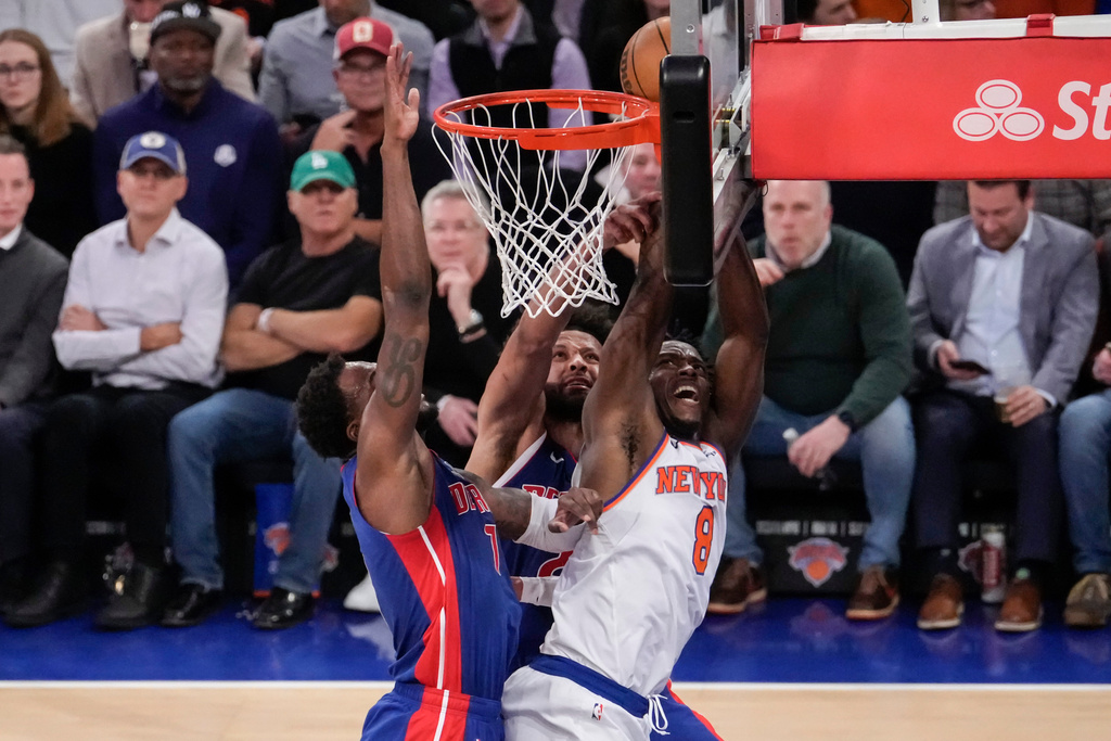 New York Knicks forward Og Anunoby (8) is blocked by Detroit Pistons guard Cade Cunningham (2) and Detroit Pistons forward Paul Reed (7) during the first half of an NBA basketball game, Thursday, Feb. 19, 2026, in New York. (AP Photo/Yuki Iwamura)