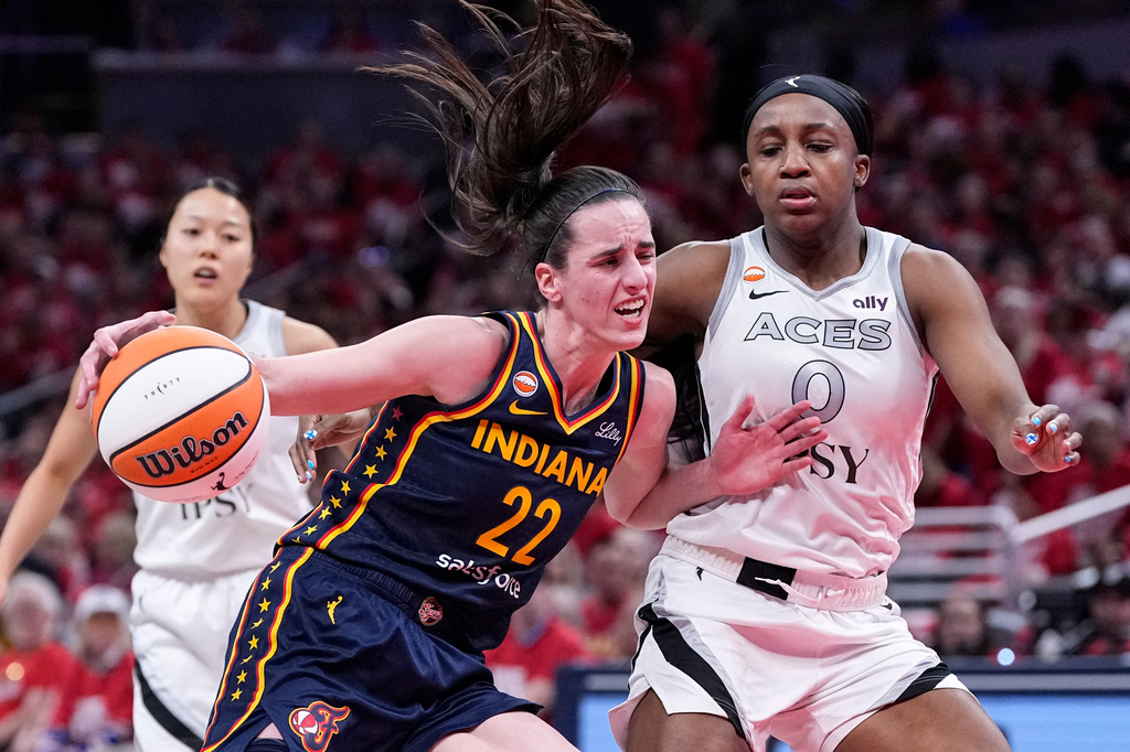 Indiana Fever guard Caitlin Clark (22) drives on Las Vegas Aces guard Jackie Young (0) during the first half in Game 2 of a WNBA basketball first-round playoff series in Indianapolis, Tuesday, Sept. 29, 2026. (AP Photo/Michael Conroy)