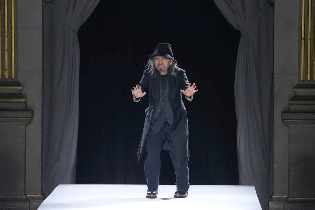 Designer Yohji Yamamoto accepts applause after the Yamamoto Spring/Summer 2026 collection presented in Paris, Friday, Oct. 3, 2025. (AP Photo/Christophe Ena)