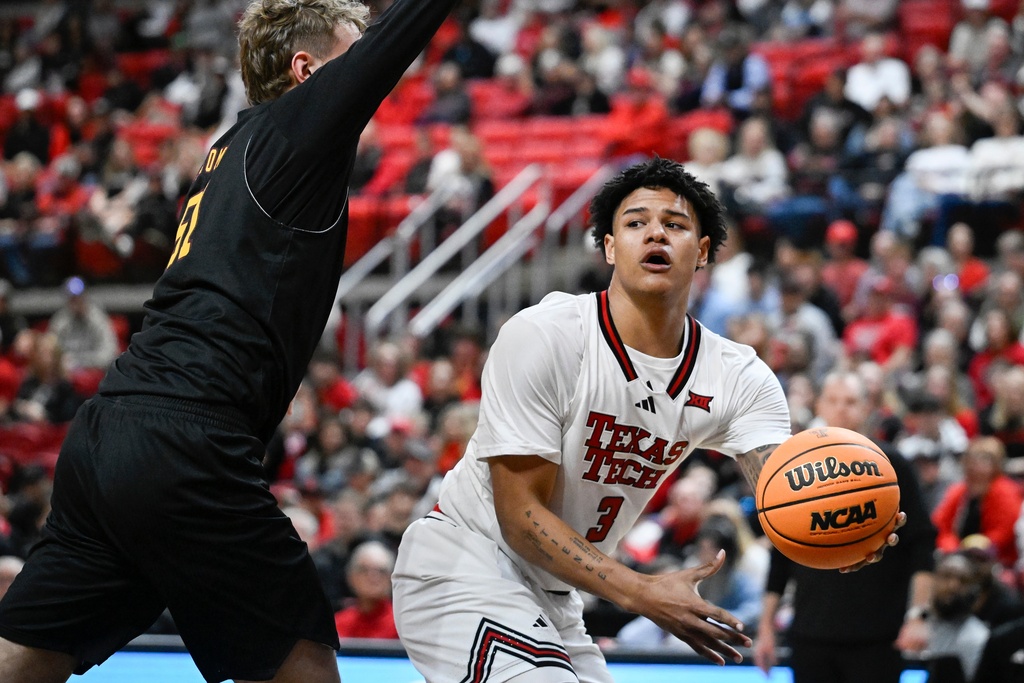 Texas Tech forward Lejuan Watts (3) passes the ball around Winthrop center Logan Duncomb, left, during the first half of an NCAA college basketball game Sunday, Dec. 28, 2025, in Lubbock, Texas. (AP Photo/Justin Rex)