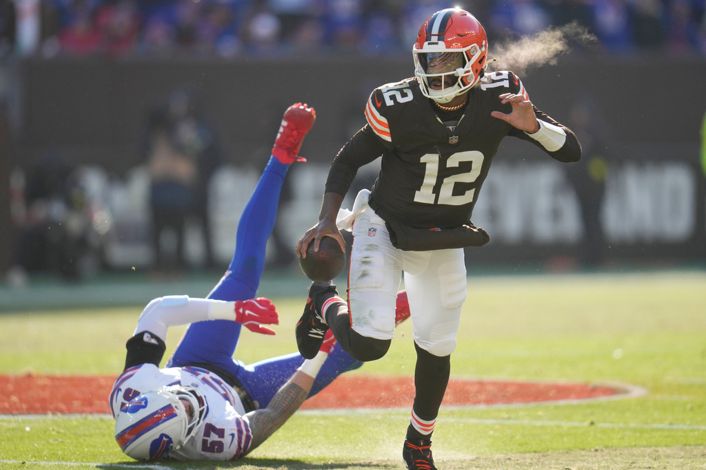 Cleveland Browns quarterback Shedeur Sanders eludes the tackle of Buffalo Bills defensive end AJ Epenesa (57)during the first half of an NFL football game in Cleveland, Sunday, Dec. 21, 2025. (AP Photo/Sue Ogrocki)