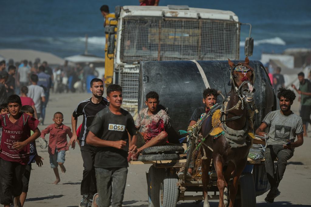A Palestinian man injured by Israeli artillery fire targeting a group of civilians fleeing from northern Gaza to the south is evacuated on a horse-drawn cart, in central Gaza, Wednesday, Oct. 1, 2025. (AP Photo/Jehad Alshrafi)