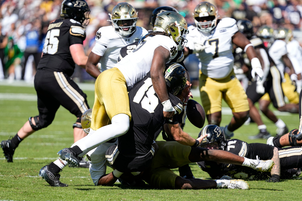 Notre Dame defensive lineman Boubacar Traore (5) sacks and forces a fumble by Purdue quarterback Ryan Browne (15) during the first half of an NCAA college football game in West Lafayette, Ind., Saturday, Sept. 26, 2026. (AP Photo/Michael Conroy)